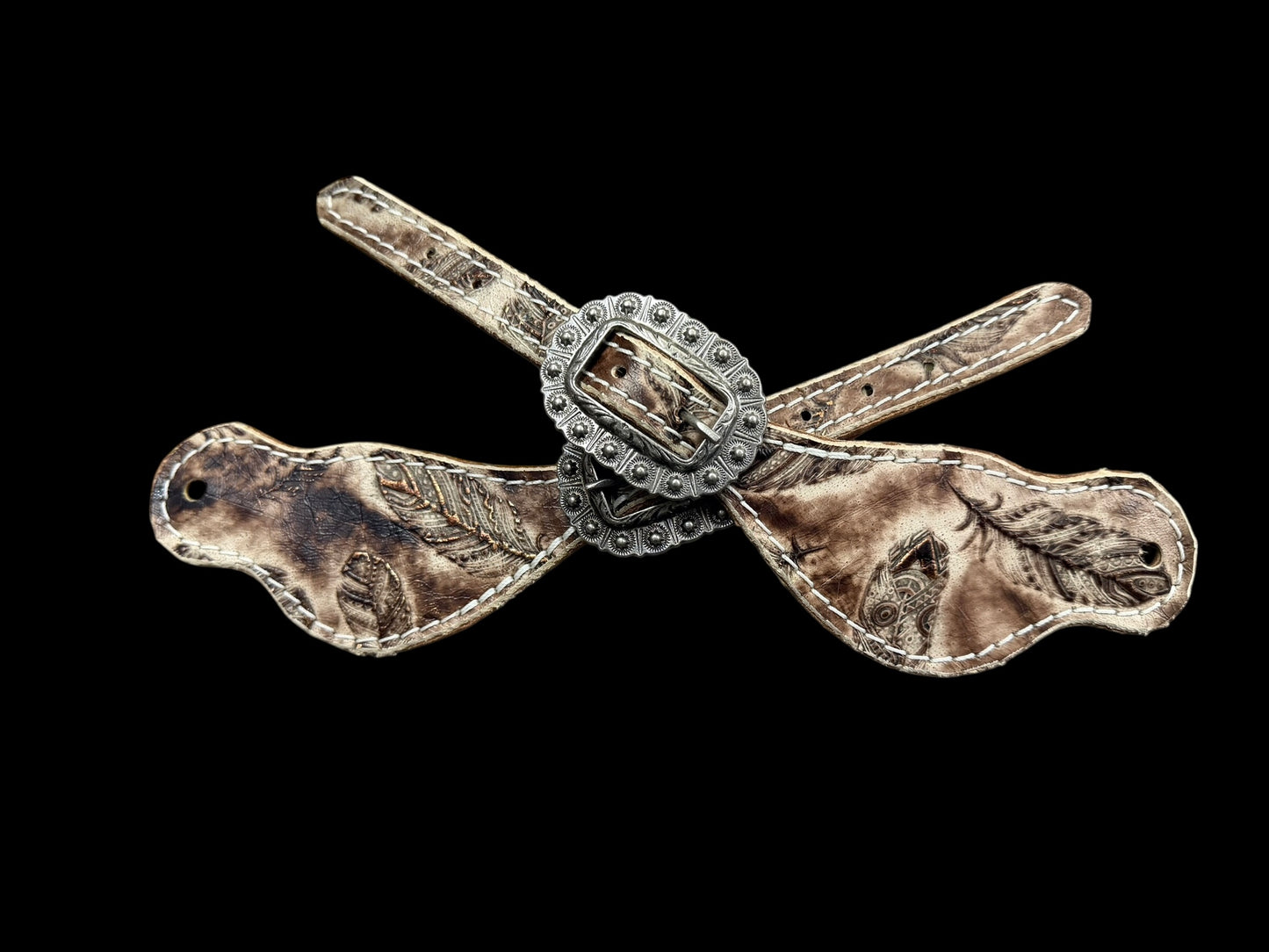 Cream and brown feathers on dark leather