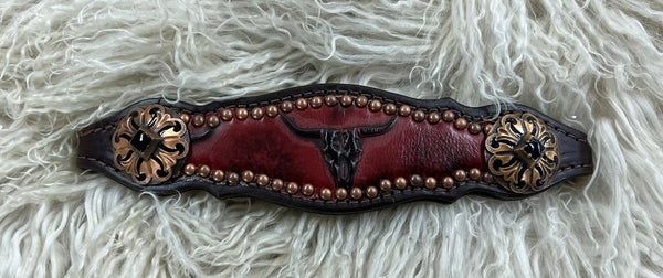 Red longhorns on dark leather
