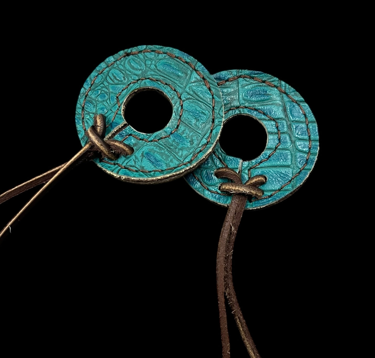 Teal gator on dark leather